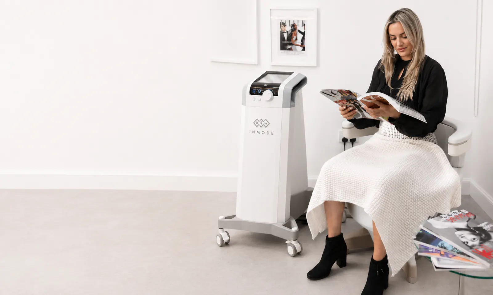 A patient reading while seated on a chair for pelvic floor treatment at 23MD