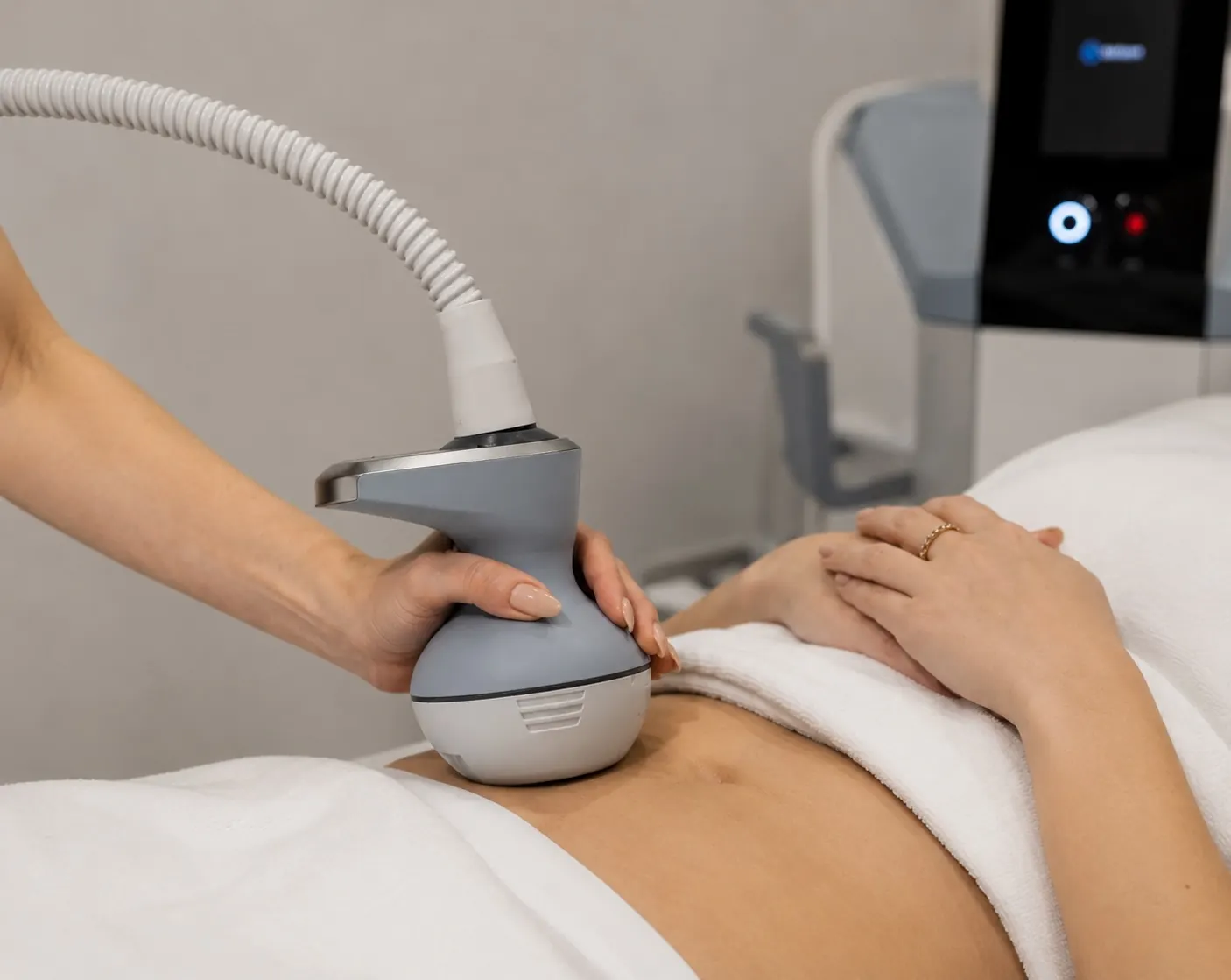 A body treatment applicator being applied to a patient's abdomen at 23MD