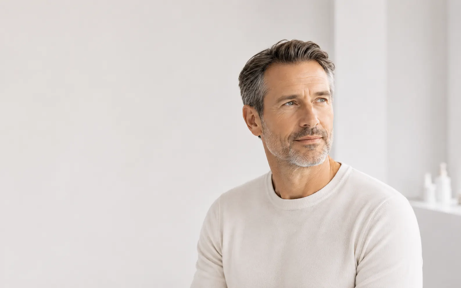 A seated man in light clothing illustrating the subject of men's hormonal health care at 23MD
