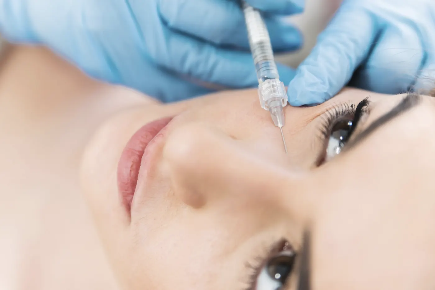 Gloved hands applying treatment near a patient's eye illustrating an archived health article at 23MD